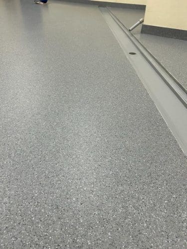 Grijze gepolijste vloer in een binnenruimte.